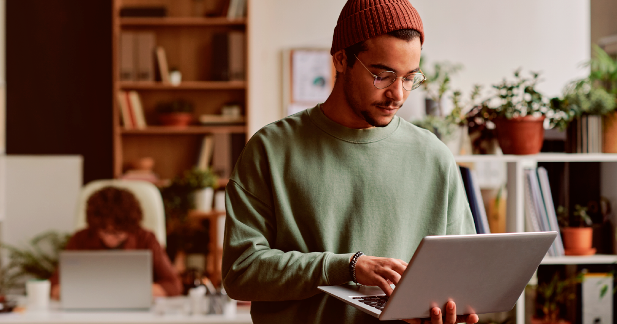 Homem branco digitando no computador.